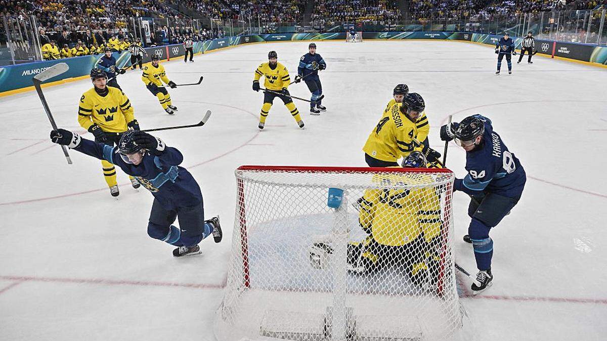Finland's #15 Anton Lundell (L) reacts after scoring his team second goal past Sweden's #32 Filip Gustavsson (C) during the men's preliminary round Group B Ice Hockey match between Finland and Sweden at the Milano Santagiulia Ice Hockey Arena during the Milano Cortina 2026 Winter Olympic Games in Milan, on February 13, 2026. (Photo by Alexander NEMENOV / POOL / AFP via Getty Images)