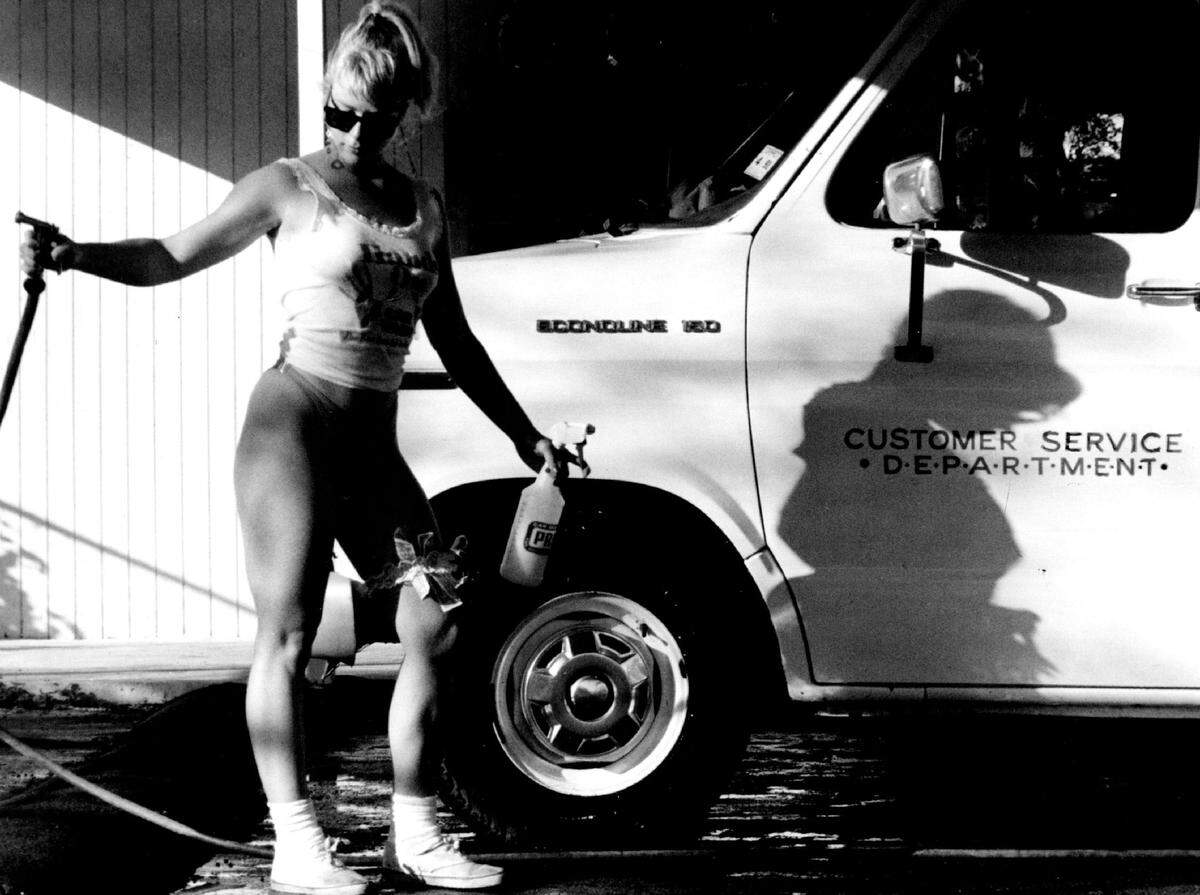 An employee of Hands On Car Wash in Fort Lauderdale washes a van in 1990.