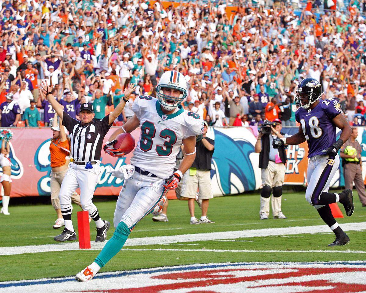 The Miami Dolphins host the Baltimore Ravens at Dolphin Stadium in Miami. Dolphins wide receiver Greg Camarillo is all smiles as the ref and fans signal his winning touchdown catch in overtime.JOE RIMKUS JR./ MIAMI HERALD STAFF
