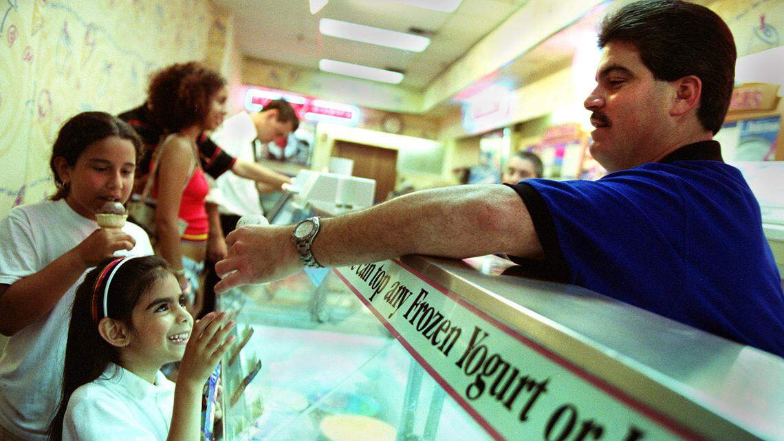 In this May 1, 2002 file photo, Carlos Bellas (right), owner of the Baskin-Robbins ice cream parlor on Lincoln Road in Miami Beach, handed a scoop of ice cream to Milena Cajina, then-7, (left) as her friend, Julianna Mercado, then-10, (behind her) enjoyed hers. On Aug. 1, 2019, Baskin-Robbins introduced two vegan options to its growing flavors library.