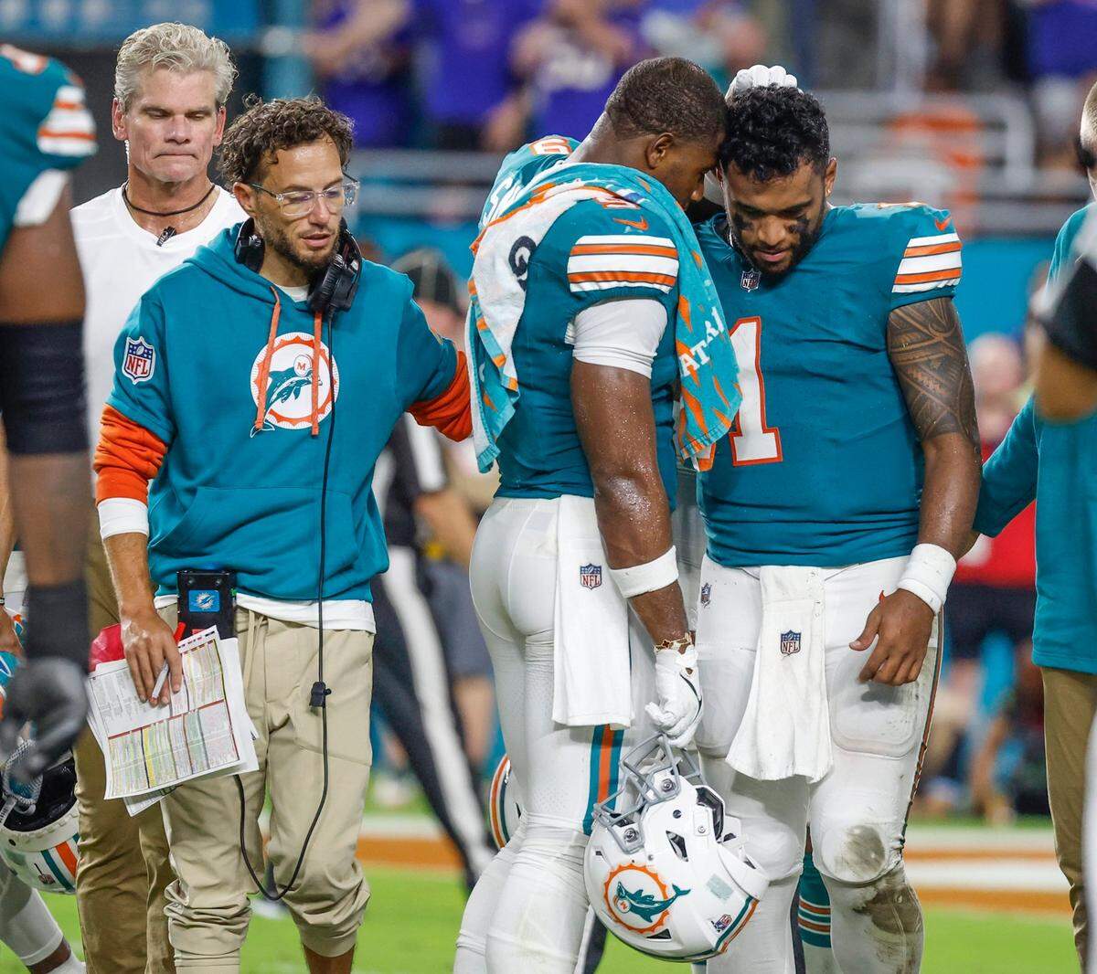 Miami Dolphins tight end Jonnu Smith (9) consoles Miami quarterback Tua Tagovailoa (1) after Tagovailoa suffers a concussion during an NFL game against the Buffalo Bills at Hard Rock Stadium on Thursday, September 12, 2024.