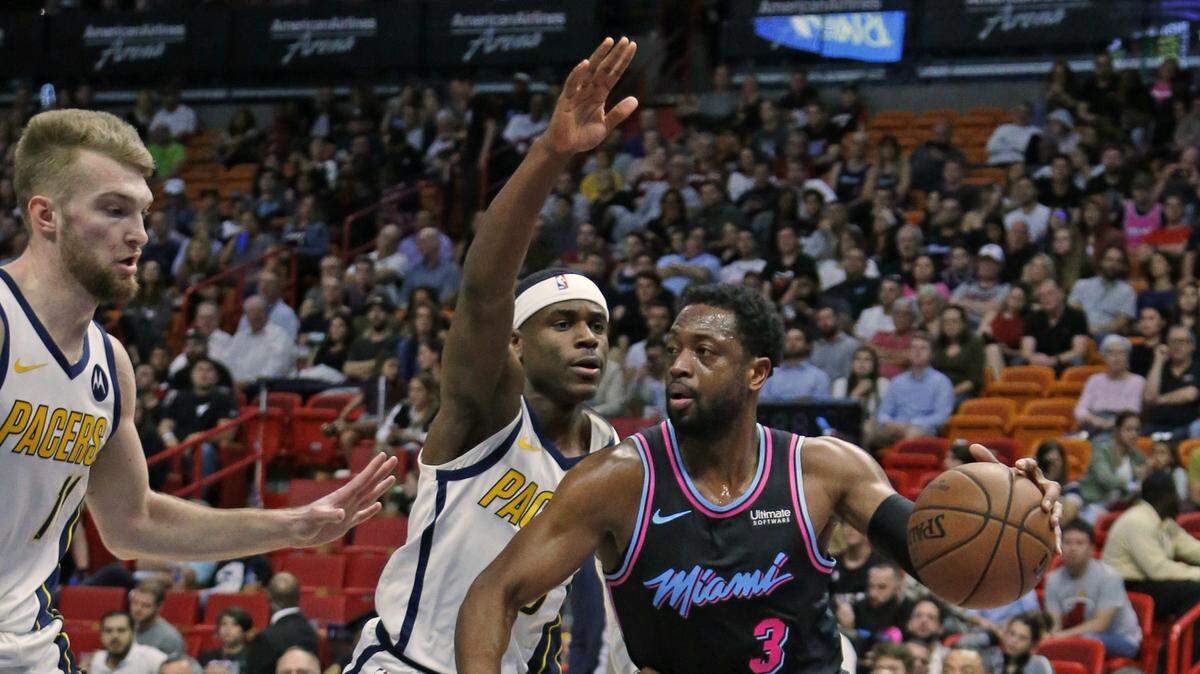 El escolta del Heat Dwyane Wade (3) trata de penetrar al aro frente al defensa de los Pacers Aaron Holiday (3) este sábado en el American Airlines Arena.