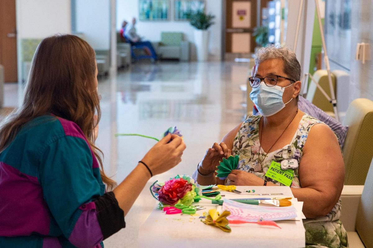 Resident artist Monica Lopez provides cancer support therapy services to patient Elizabeth Escobar through art at the Miami Cancer Institute at Baptist Health South Florida in Miami on Wednesday, May 12, 2021.