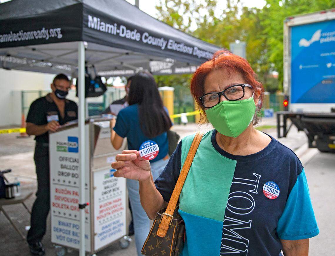 Miami-Dede resident Zaida Perez shows her sticker after casting her vote on first day of early voting for the general election at Shenandoah Branch Library located at 2111 SW 19th St. on Monday, October 19, 2020, in Miami, Florida.