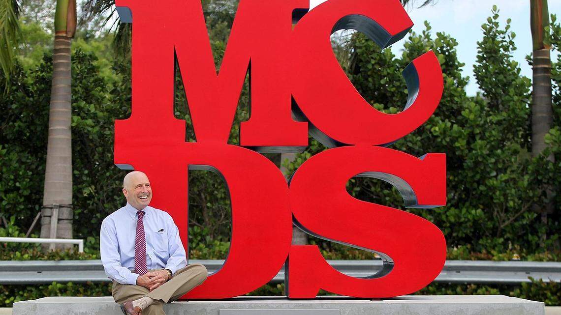 Dr. John Davies, longtime head of Miami Country Day School, is retiring after 32 years in the community. Here, he is sitting next to a sculpture he designed after being inspired by artist Robert Indiana on Wednesday, June 6, 2018.
