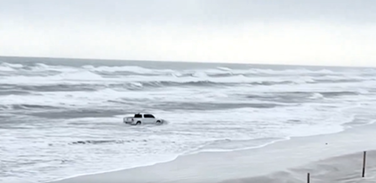 A man in Florida drove around a sign marking a closed beach and then drove into the waves, a video shows.