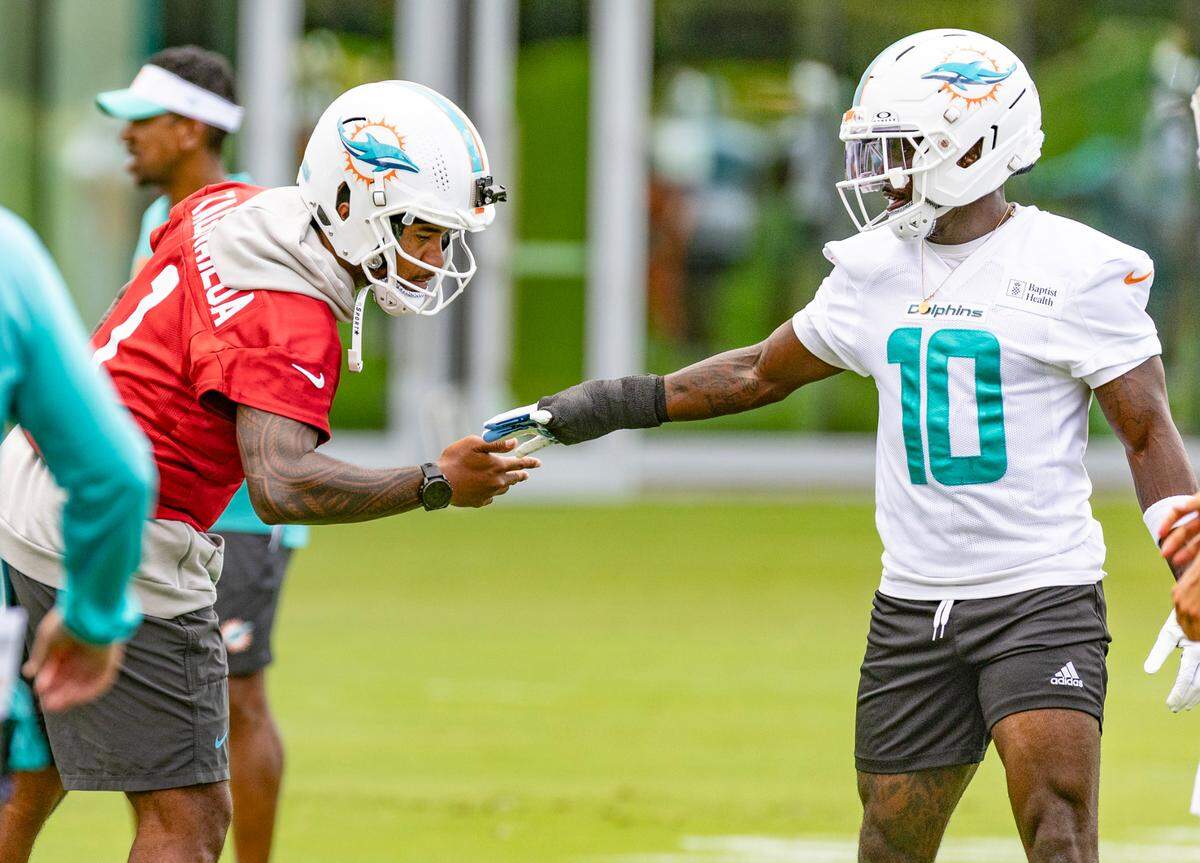 Miami Dolphins quarterback Tua Tagovailoa (1) greets wide receiver Tyreek Hill (10), who has a bandages hand, during OTA’s “Organized Team Activities,” at the Baptist Health Training Complex in Miami Gardens, Florida, on Wednesday, May 28, 2025.
