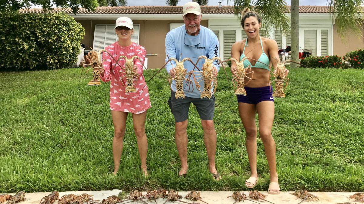 Christine Hawk, left, Jim 'Chiefy' Mathie and Silvia Garavito show off the lobsters they caught on a recent dive trip with Mathie out of Deerfield Beach.