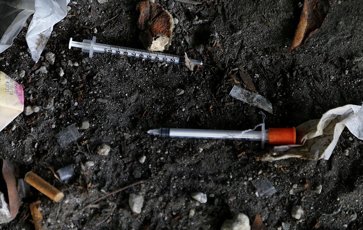 Several syringes spread all over were among the many different items found on the sidewalk as Miami crews cleaned an area in Overtown under the highway early Friday.