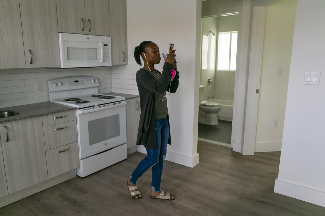 Resident Quantanae Byrd, 25, records a video of a renovated apartment during the “Move-In Celebration” at the 16 Corner project in Overtown.