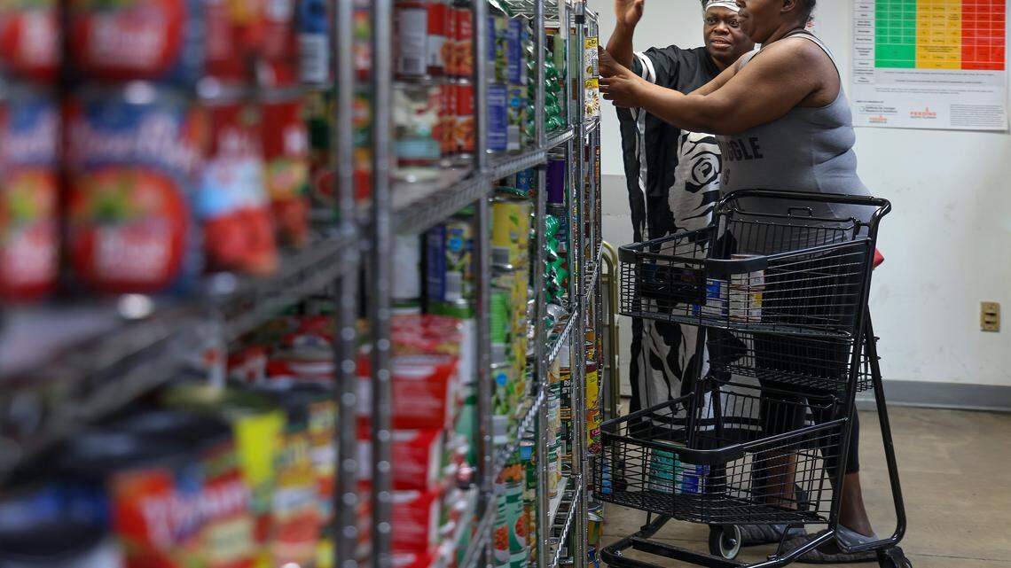 Jackie Brown, 57, left, and Lathoya Bennett, 49, right, shop in the canned food section. They have relied on Feeding South Florida's pantry in Pembroke Park for the past two years to bridge the gap between food stamp payments. 