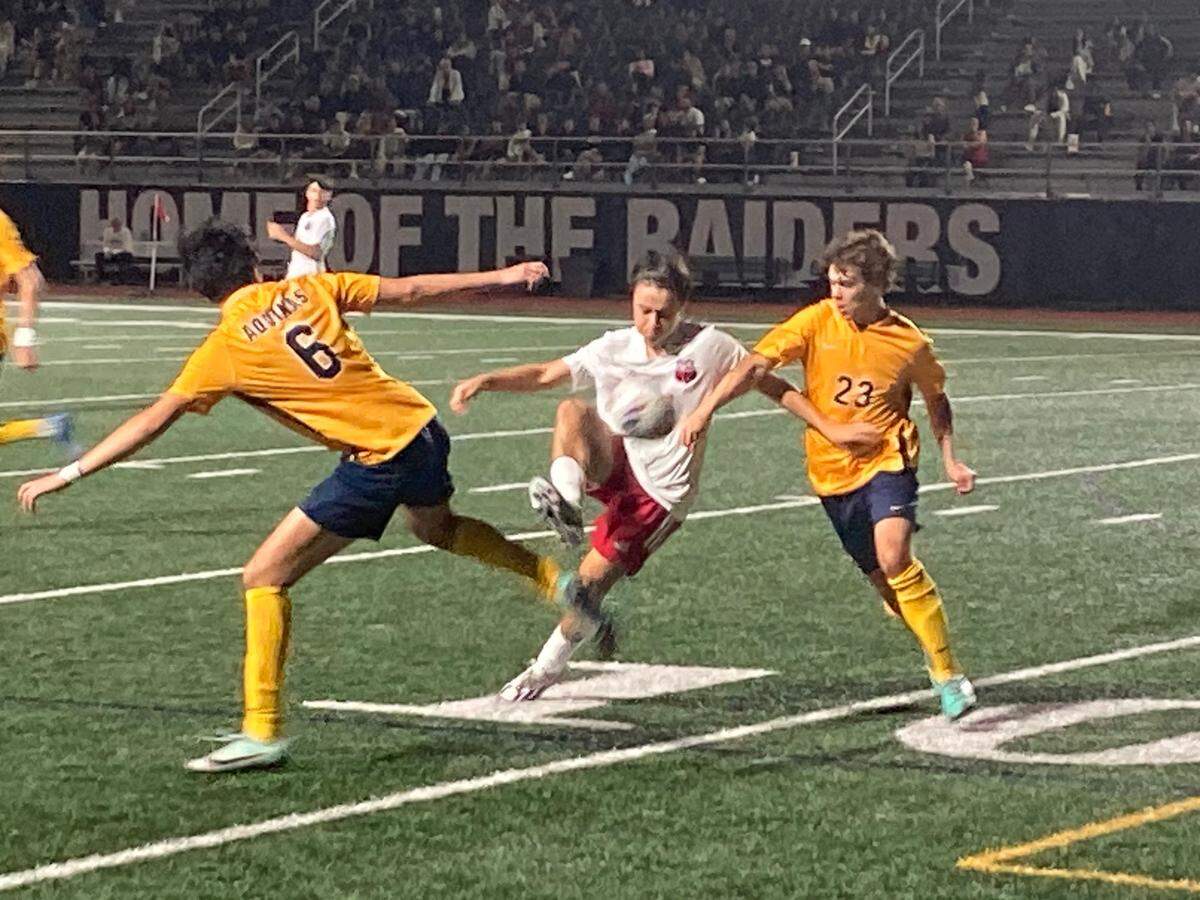 Miami Beach midfielder Matias Orozco tries to knife his way through St. Thomas defenders Francesco Ninfole (left) and Chase Goyette (right) during Friday night’s Region 4-6A semifinal at St. Thomas Aquinas High School.