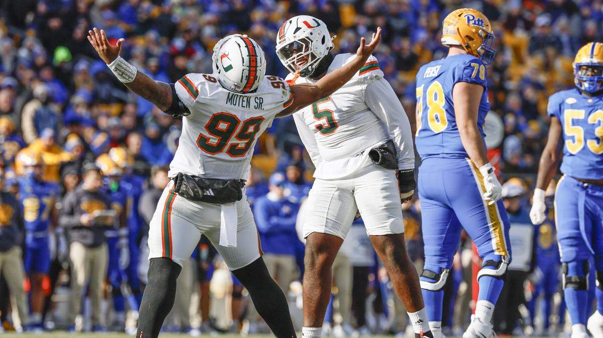 Miami Hurricanes defensive lineman Ahmad Moten (99) and defensive lineman Justin Scott (5) react after Moten sacks Pittsburgh Panthers quarterback Mason Heintschel (6) on the opening play of the game in the first half during their NCAA football game at Acrisure Stadium in Pittsburgh, PA, on Saturday, November 29, 2025.
