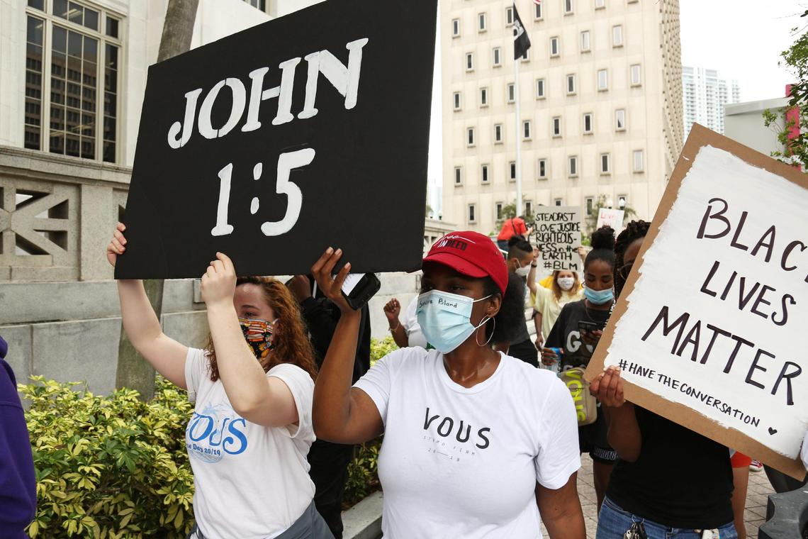 Demonstrators and people of faith are seem marching outside the Miami-Dade County Courthouse as they participate in a prayer walk event organized by Touching Miami going from Bayfront Park to downtown Miami and back to show solidarity and seek justice, on Saturday, June 6, 2020.