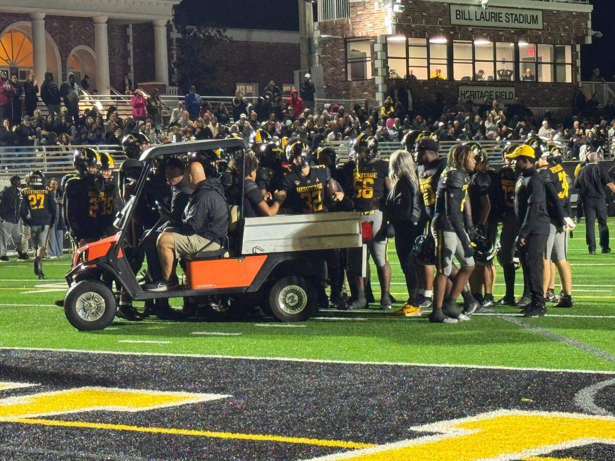 Teammates huddle around American Heritage quarterback Dia Bell, who was carted off the field with his right leg in an air cast during Friday’s Region 4-4A semifinal against Dillard at Heritage’s home field.