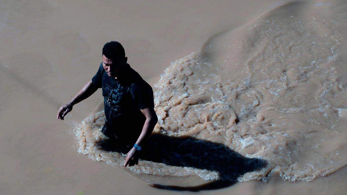 A man wades across a flooded road in Honduras after Hurricane Eta struck the country.