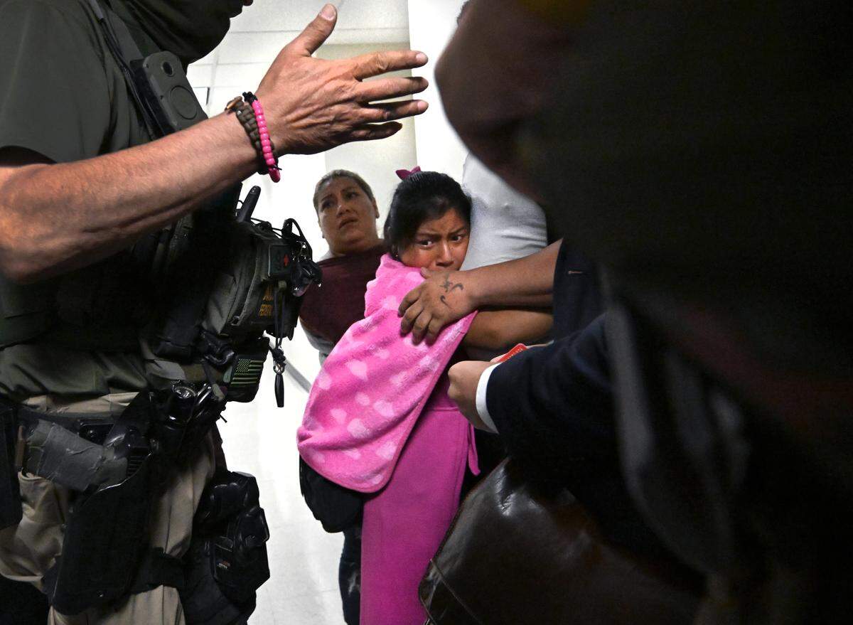 Scarlett. 10, clings to her father  as ICE agents detain him after his immigration court hearing at the Jacob K. Javits Federal Building in New York on July 31, 2025.   