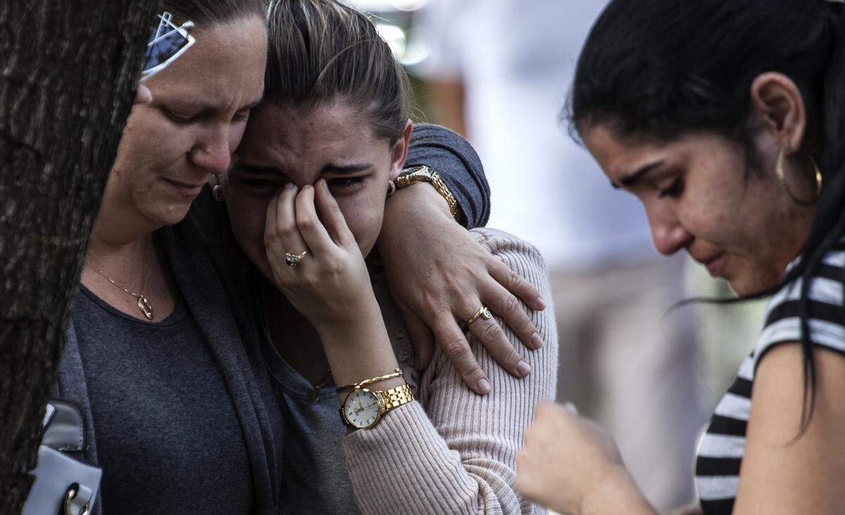 Three women shed tears after the identification of the victims of the Havana airplane crash at the Institute for Forensic Medicine on May 19, 2018, in Havana.