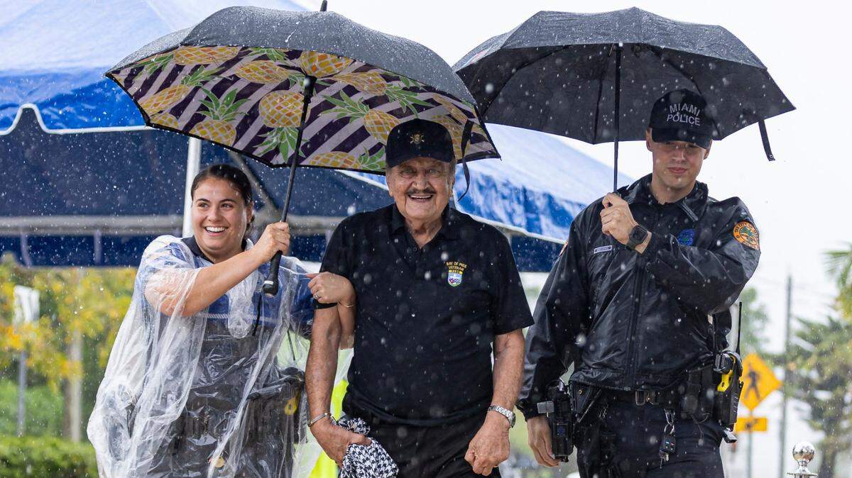 Officers Alexia Reyes, left, and Ryan Dreseris help Arturo Sanchez-Bella, 87, center, make his way to a commemoration at the Bay of Pigs Memorial Park in Miami on April 12.
