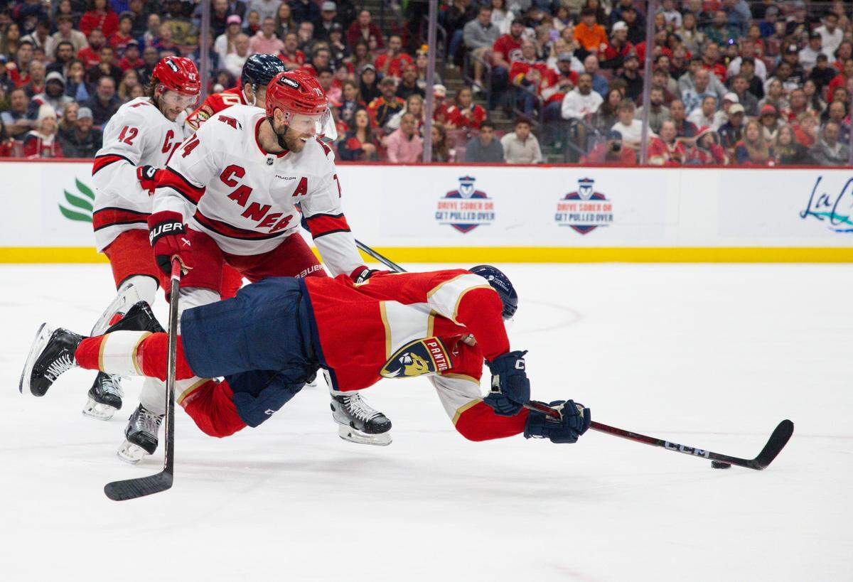 Florida Panthers left wing Tomas Nosek (92) dives around Carolina Hurricanes defenseman Jaccob Slavin (74) for the puck during the second period of a game on Thursday, Jan. 2, 2025, at Amerant Bank Arena in Sunrise, Fla.