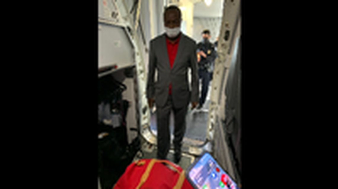 Jean-Charles Moise enters a plane in Miami en route to Haiti Behind him is a Customs and Border Protections officer. The photo went viral in Haiti.