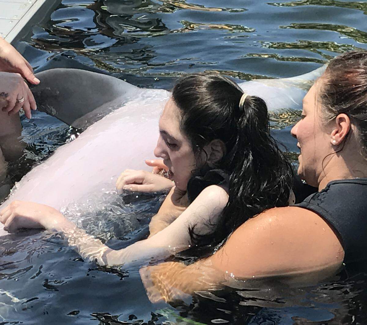 Ashtyn Montali pets the belly of a bottlenose dolphin at Island Dolphin Care in Key Largo on Wednesday, June 5, 2019.