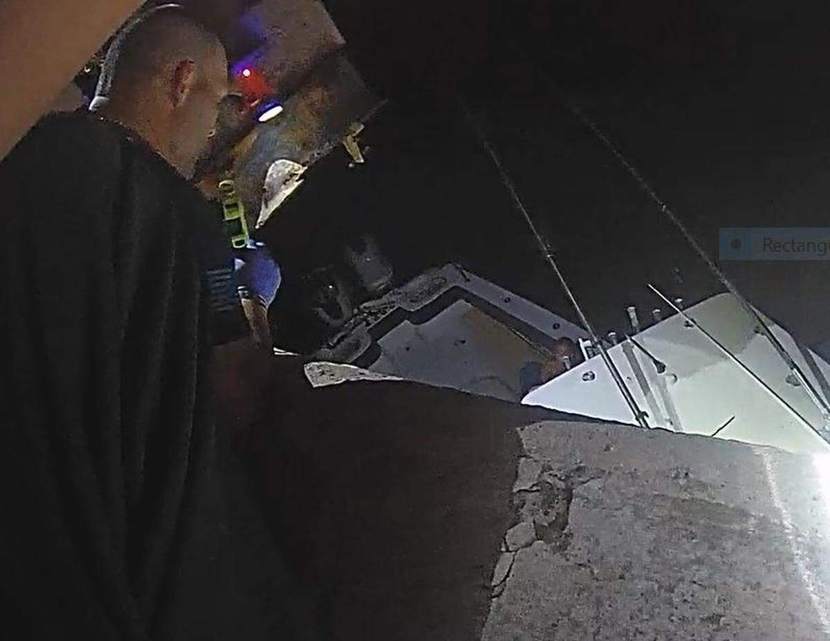 A Monroe County Sheriff’s Office deputy speaks to people on a sinking boat that crashed into a Florida Keys bridge on Monday, July 8, 2024.