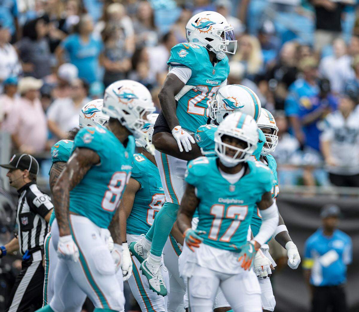 Miami Dolphins running back De’Von Achane (28) celebrates with teammates after scoring a touchdown during the first half of an NFL football game against the Carolina Panthers, Sunday, Oct. 5, 2025, in Charlotte, N.C.