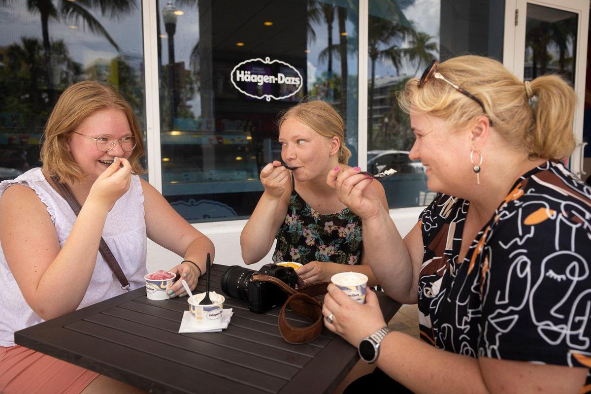 Olga Enns, right, and her nieces, Felesha Maas, left, and Jennifer, center, all from Germany, take an ice cream break in South Beach on their vacation in South Florida. Like most other days this week, it hit at least 90 degrees on Thursday, July 13, 2023 int the Miami area. “It’s hot, but we like it here in Florida because it’s beautiful,” Enns said ashe she ate her Häagen-Dazs.