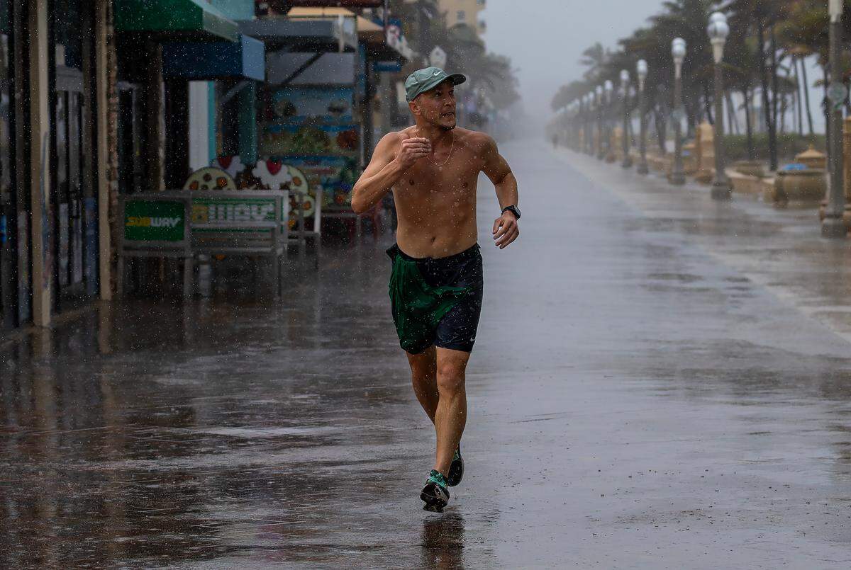 Pavel Matorny of South Florida runs through the rain along the Hollywood Beach Broadwalk on Monday, May 12, 2025. The National Weather Service in Miami forecasts widespread showers and thunderstorms throughout the day, with a 90% chance of precipitation and 1 to 3 inches of rain expected by Tuesday morning.