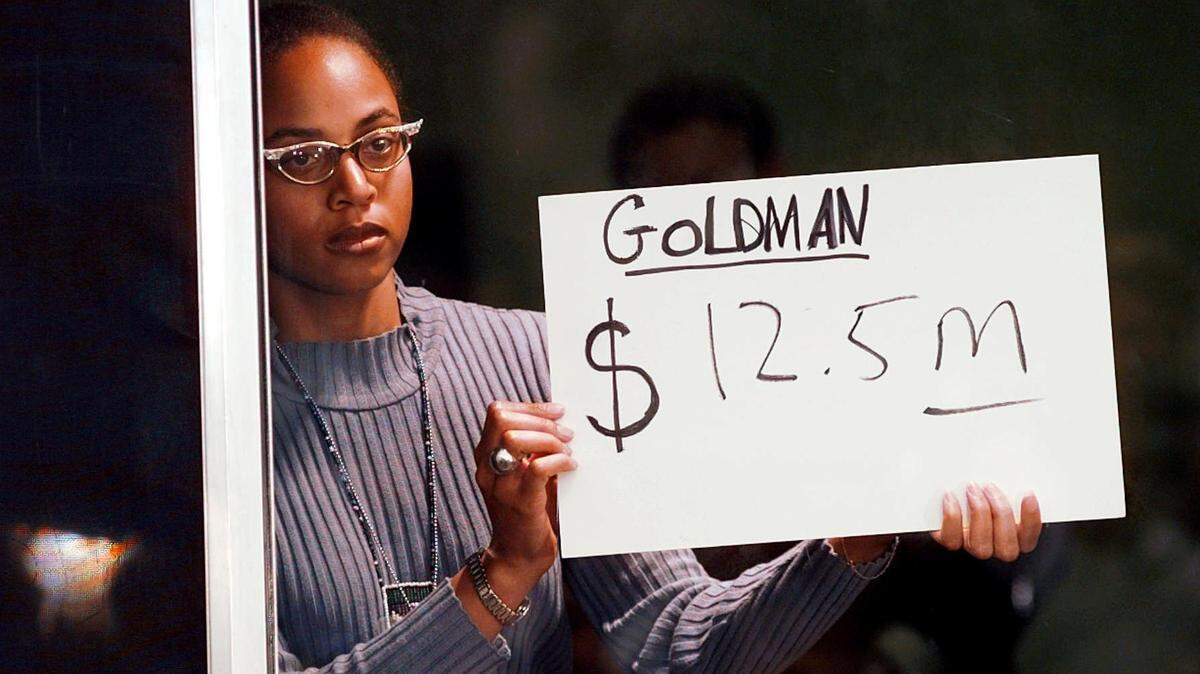 An unidentified woman holds up a card announcing to the media that the jury has awarded the Goldman family $12.5 million at Los Angeles County Superior Court in Santa Monica, Calif., Monday, Feb. 10, 1997 in the punitive phase of the O.J. Simpson civil trial.(AP Photo/Eric Draper)