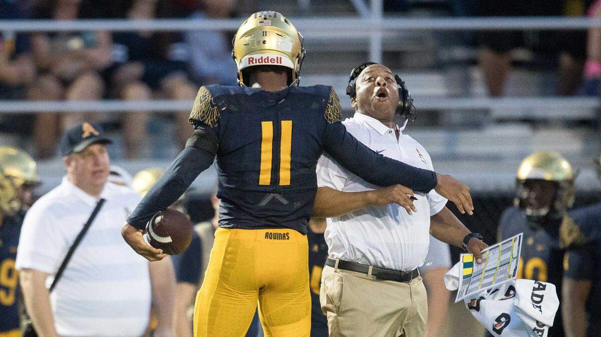 St. Thomas Aquinas’ Anthony Solomon (11) celebrates a win with one of the assistant coaches during the nationally televised football matchup between DeMatha and St. Thomas Aquinas on Saturday August 25, 2018. St. Thomas won 38-0.