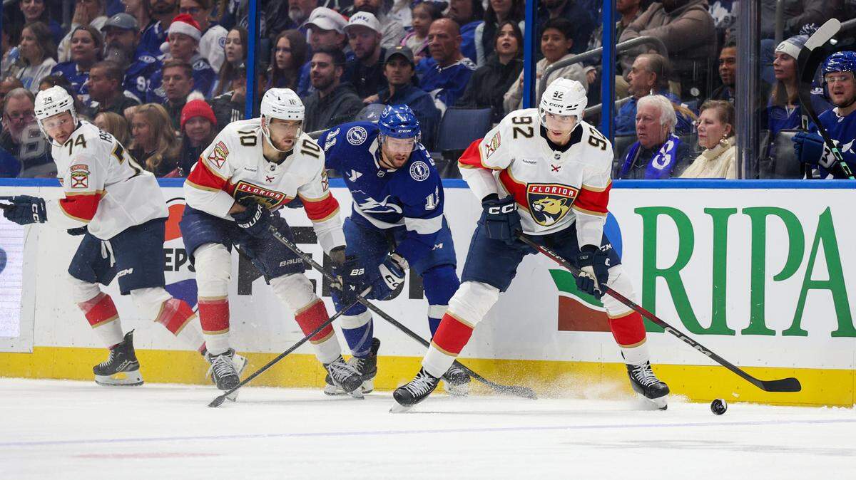 Dec 22, 2024; Tampa, Florida, USA; Florida Panthers left wing Tomas Nosek (92) controls the puck from Tampa Bay Lightning center Luke Glendening (11) in the third period at Amalie Arena.