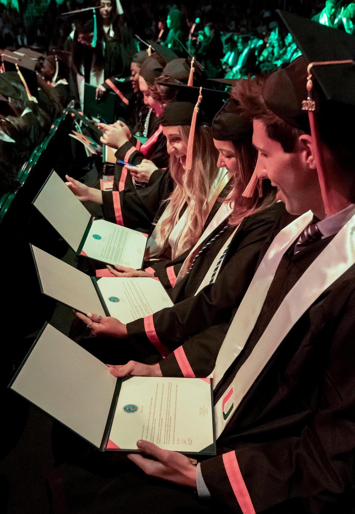 Right to left, Alexander Miller, Charleigh Peters and Gillian Drexler check out their diplomas during the University of Miami’s spring commencement ceremony. The College of Arts & Sciences and the Division of Continuing & International Education graduated during a ceremony Friday morning.