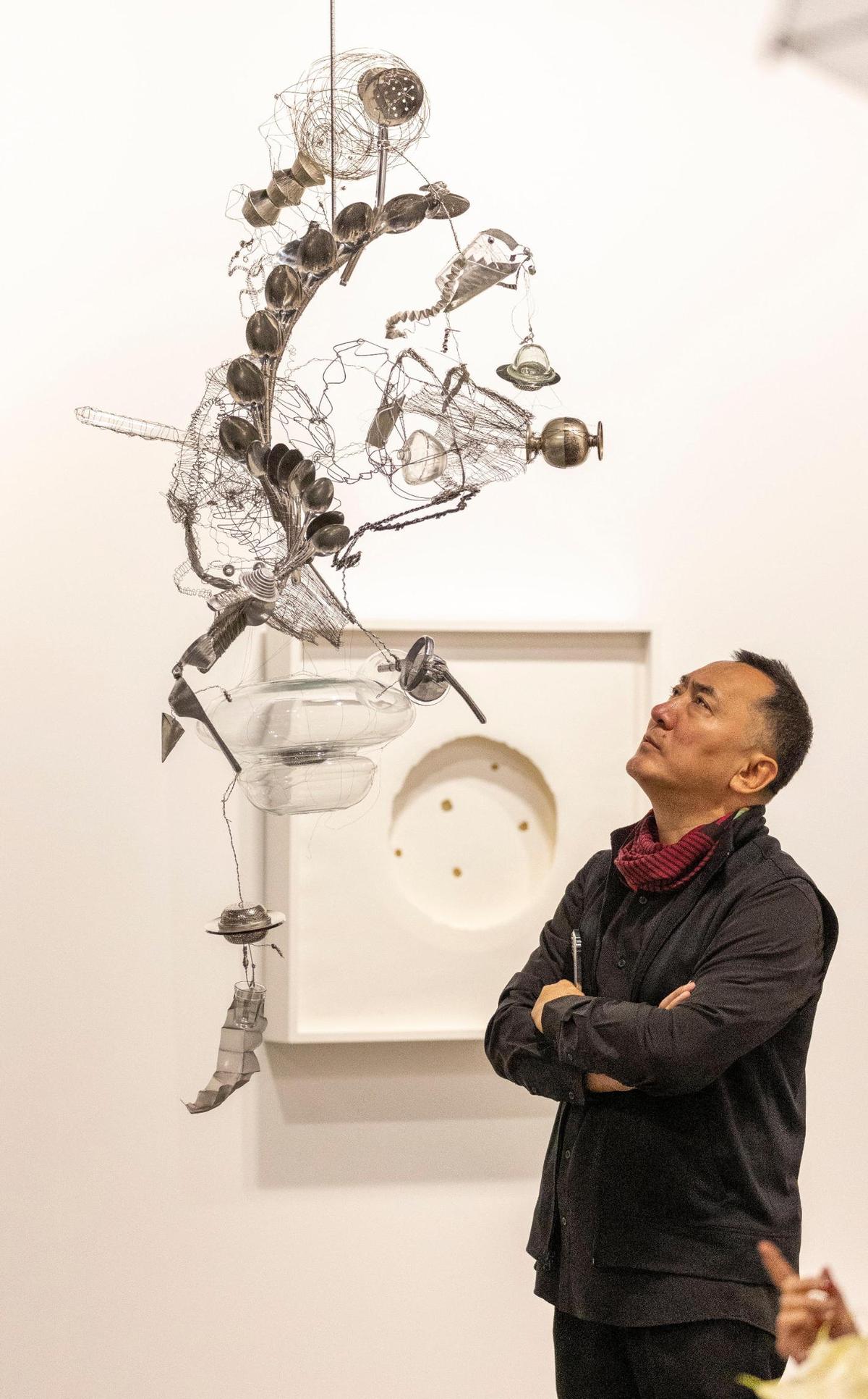 A man inspects a Laura Lima’s ‘Disco Volador #18.’