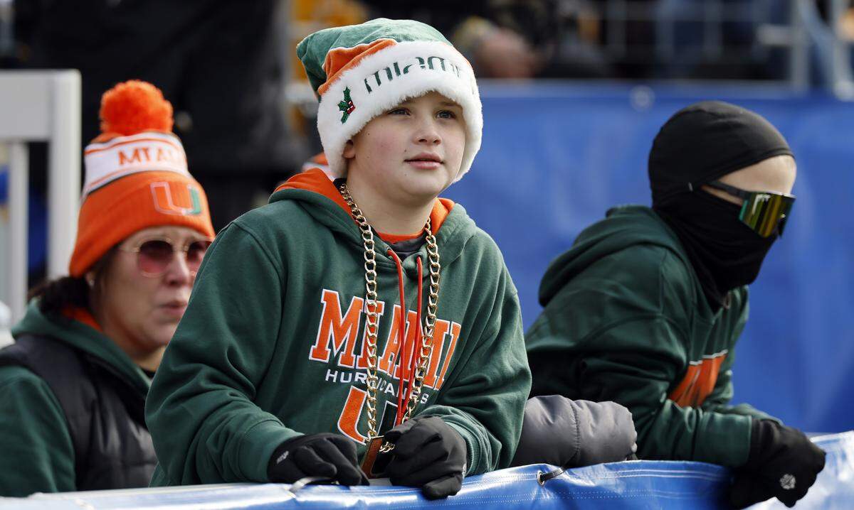 Miami Hurricanes fan Dougie Kilburn, 9, dresses warm for the 30-degree cold weather during the NCAA football game between the Miami Hurricanes and Pittsburgh Panthers at Acrisure Stadium in Pittsburgh, PA, on Nov. 29, 2025. If there was still a season the week of Jan. 26 and beyond fans would have to dress this way, or even in heavier jackets, as South Florida faces a prolonged cold streak.