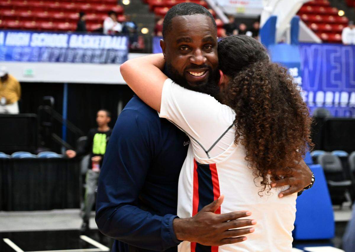 Miami Country Day head coach Ochiel Swaby is hugged by Kayla Nelms after the team won back-to-back Class 3A state championships at the RP Funding Center in Lakeland on Friday.