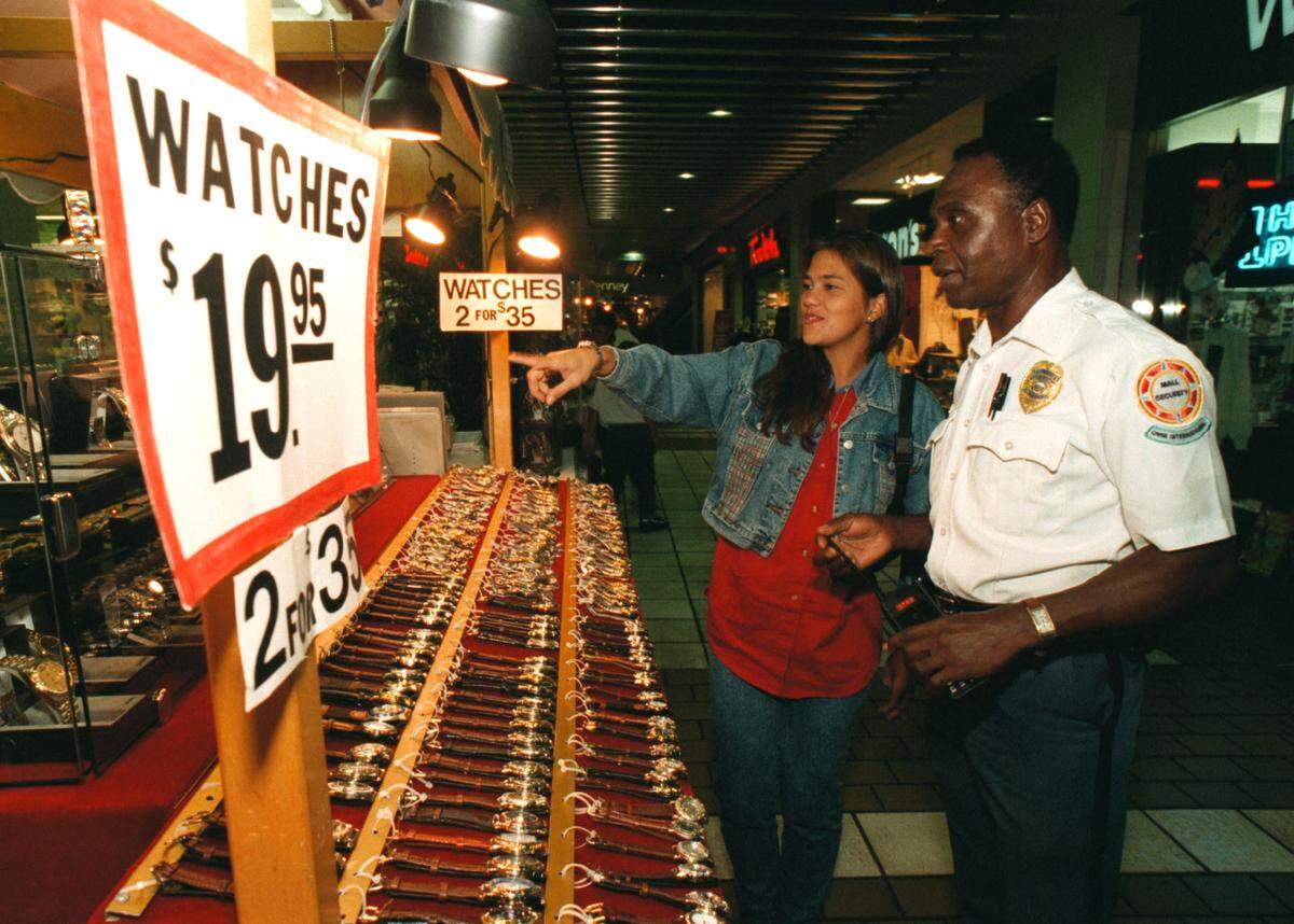 Omni mall security guard Ralph Higgins stops to talk with Maria Rocco, who sells watches from a cart in the mall.
