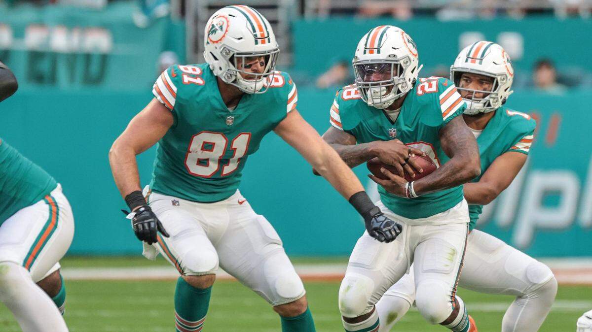 Miami Dolphins quarterback Tua Tagovailoa (1) hands off to Miami Dolphins running back Duke Johnson (28) in the first half doing game against New England Patriots at Hard Rock Stadium in Miami Gardens on Sunday, January 9, 2022.