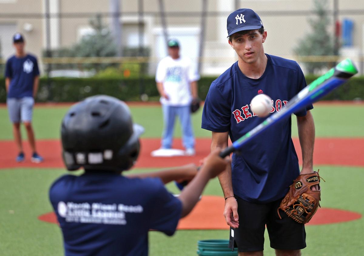 Garth Fowler, 9, who has autism, swings at a pitch from Jared Weingard, 17, at Pelican Park in Sunny Isles Beach on Sunday, Nov. 4, 2018.