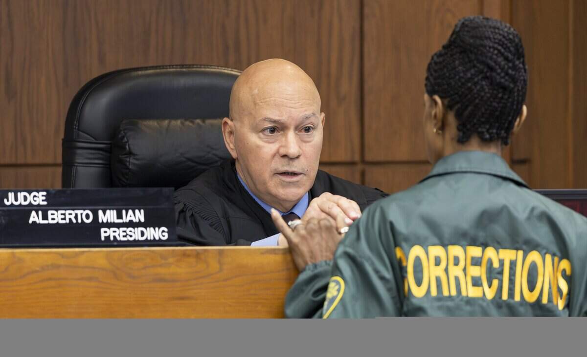Miami-Dade Circuit Judge Alberto Milian talks with a corrections officer at the Richard E. Gerstein Justice Building on Thursday, Aug. 14, 2025, in Miami, Fla. Milian is the judge who has overseen the case of Oscar Olea, a former Key Biscayne gymnastics coach who allegedly sexually abused his students.