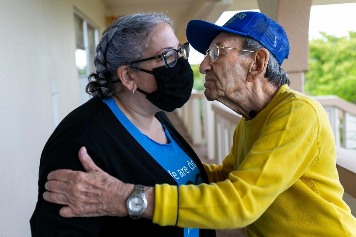 Holocaust survivor Saul Dreier, 95, right, gives Rami Spiegel, assistant director of the Holocaust Survivor Assistance Program, a kiss on the cheek after receiving a basket of food outside his home in Coconut Creek, Florida, on Tuesday, March 23, 2021.