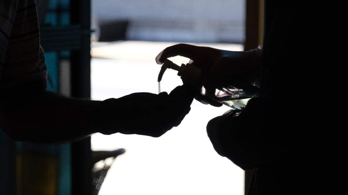 Hand sanitizer is squirted into a worshiper’s hands as they enter for a Sunday Mass at a church in Paterson, N.J.