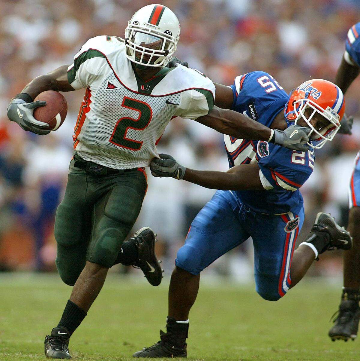 UM’s Willis McGahee gets a first down before being tackled by UF’s Robert Cromartie in Gainesville in 2002.