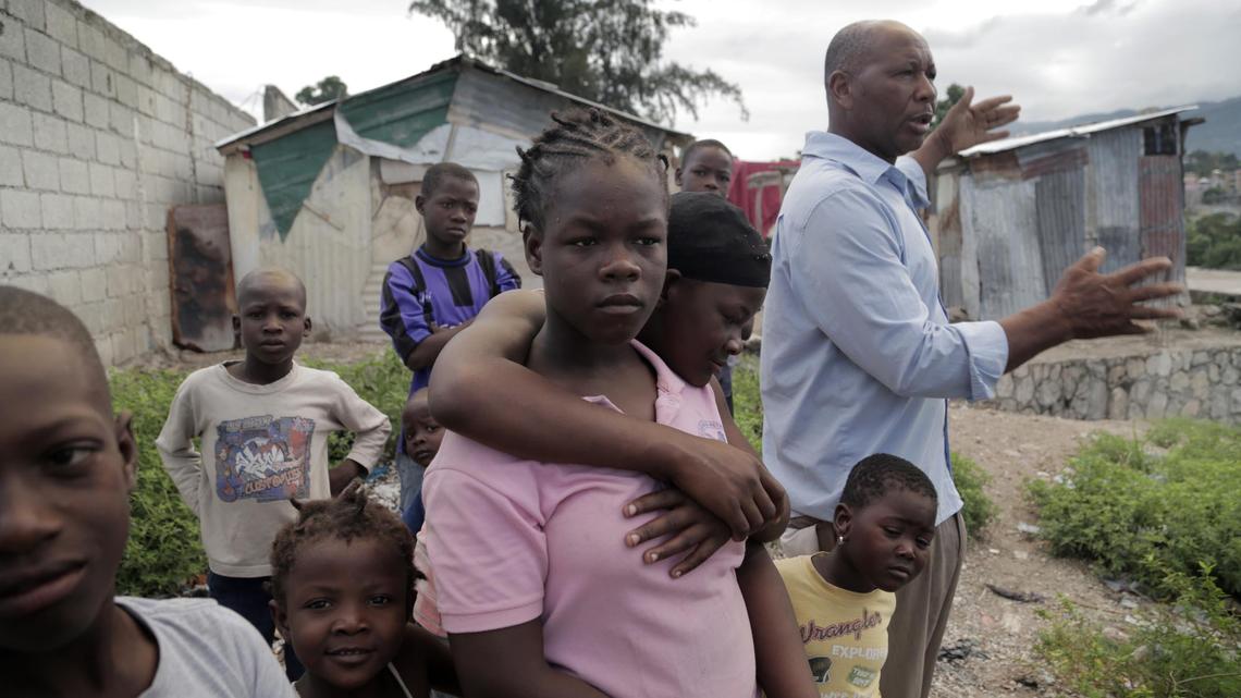 Cami Etienne, far right, talks about the situation in Haiti in the company of some of the children who live in a makeshift camp located off a dirt road in the interior of Delmas.
