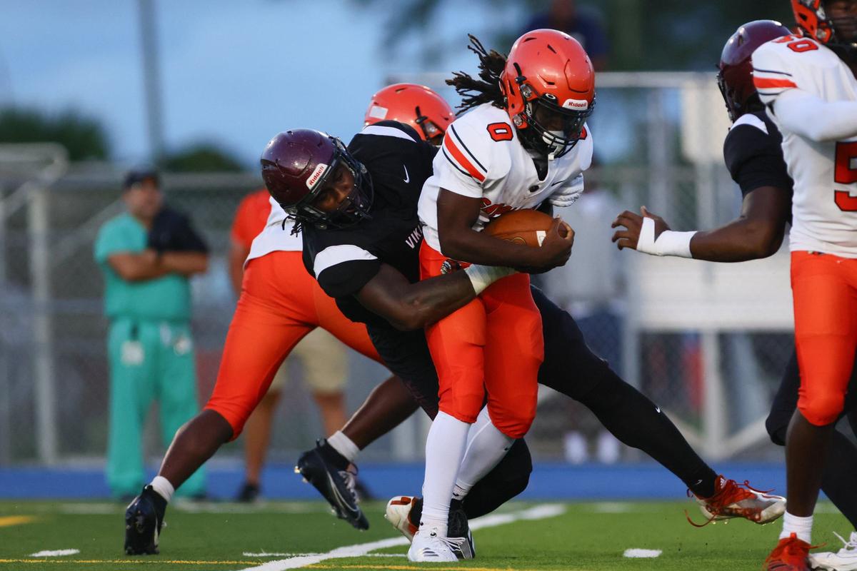 Carol City Chiefs running back Ethan Beck (0) is tackled by Norland Vikings linebacker Darryll Desir (1) during the first quarter of a high school football game at Nathaniel Traz Powell Stadium in Westview, Florida, on Friday, August 30, 2024.