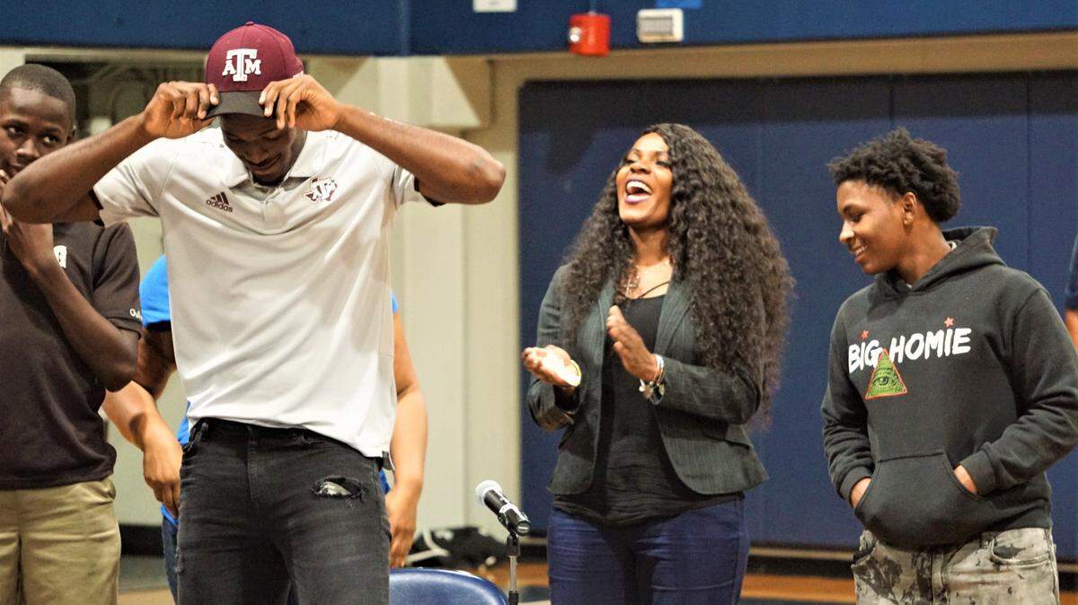 Gulliver Prep defensive end Donell Harris, puts on a Texas A&M Aggies hat at an early signing day ceremony inside the Gulliver Prep gymnasium in Pinecrest on Wednesday, Dec. 18, 2019.