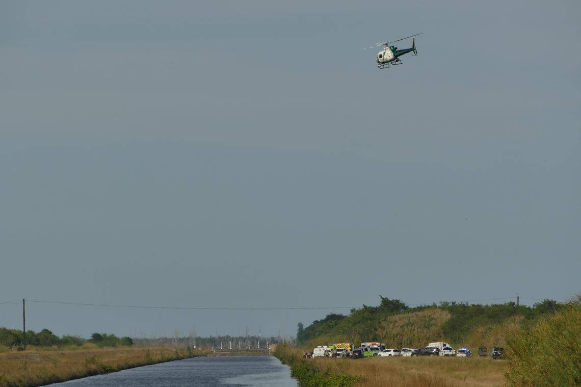 A Miami-Dade Fire Rescue helicopter searches a Southwest Miami-Dade canal after a helicopter crashed on Wednesday, Dec. 27, 2023.