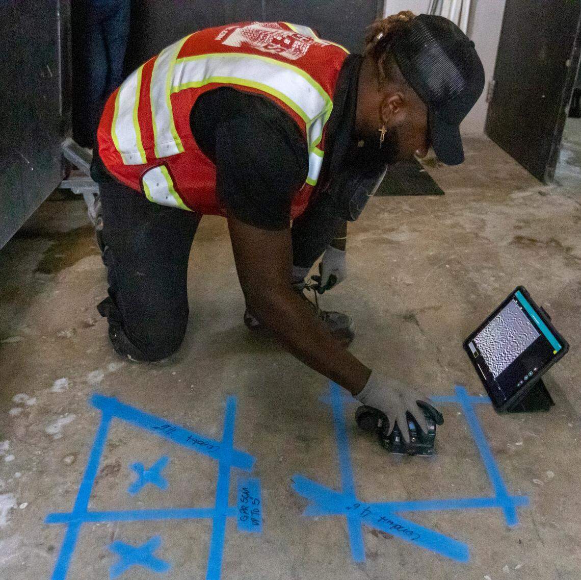 Peterson Jean-Baptiste uses ground penetrating radar on July 13, 2021, to check for anomalies in the concrete at Champlain Towers North as well as for pipes or wires that may get in the way of drilling a core sample.