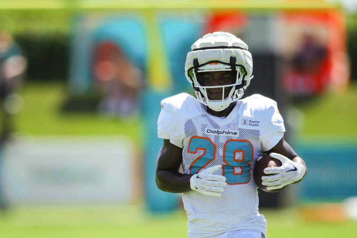 Miami Dolphins running back Devon Achane (28) runs with the ball during training camp at Baptist Health Training Facility in Miami Gardens, Florida, Monday, July 31, 2023.